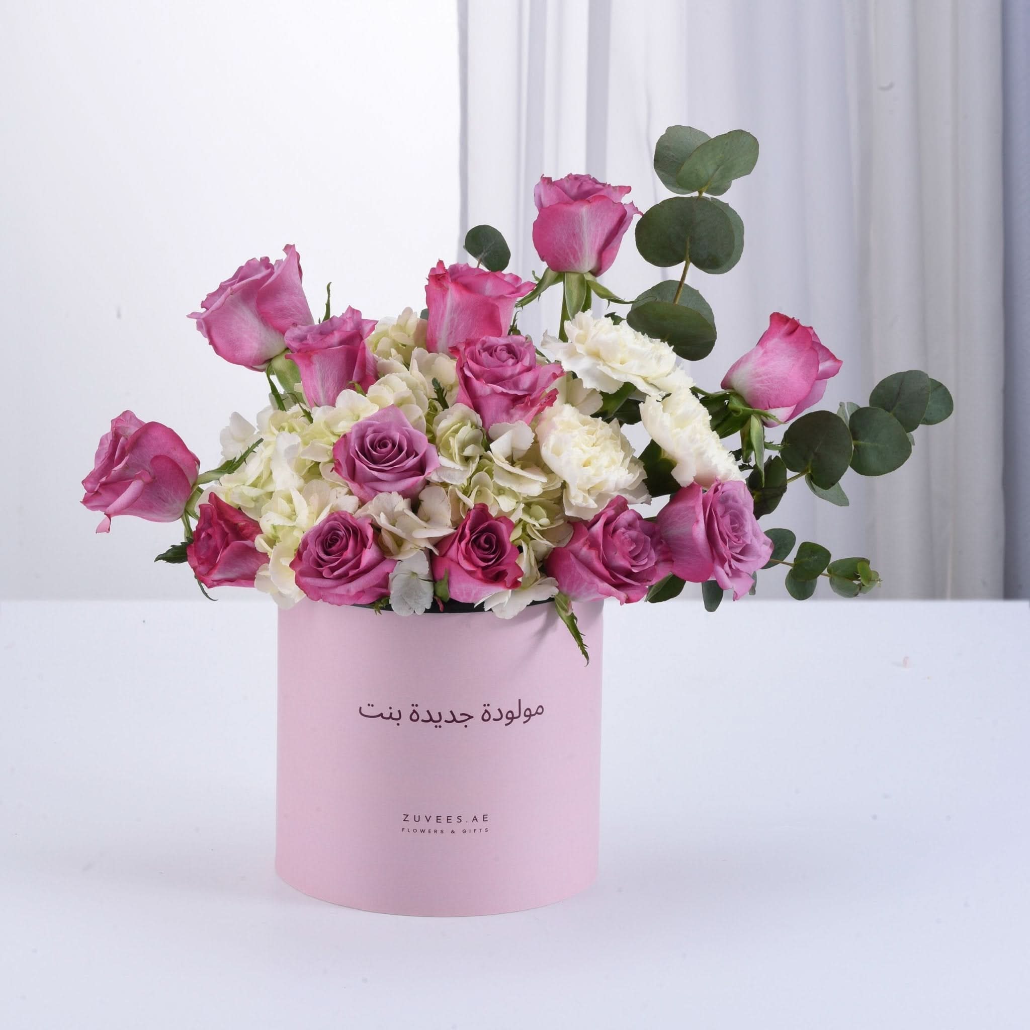 Pink roses and hydrangeas in a light pink box with Arabic greeting.