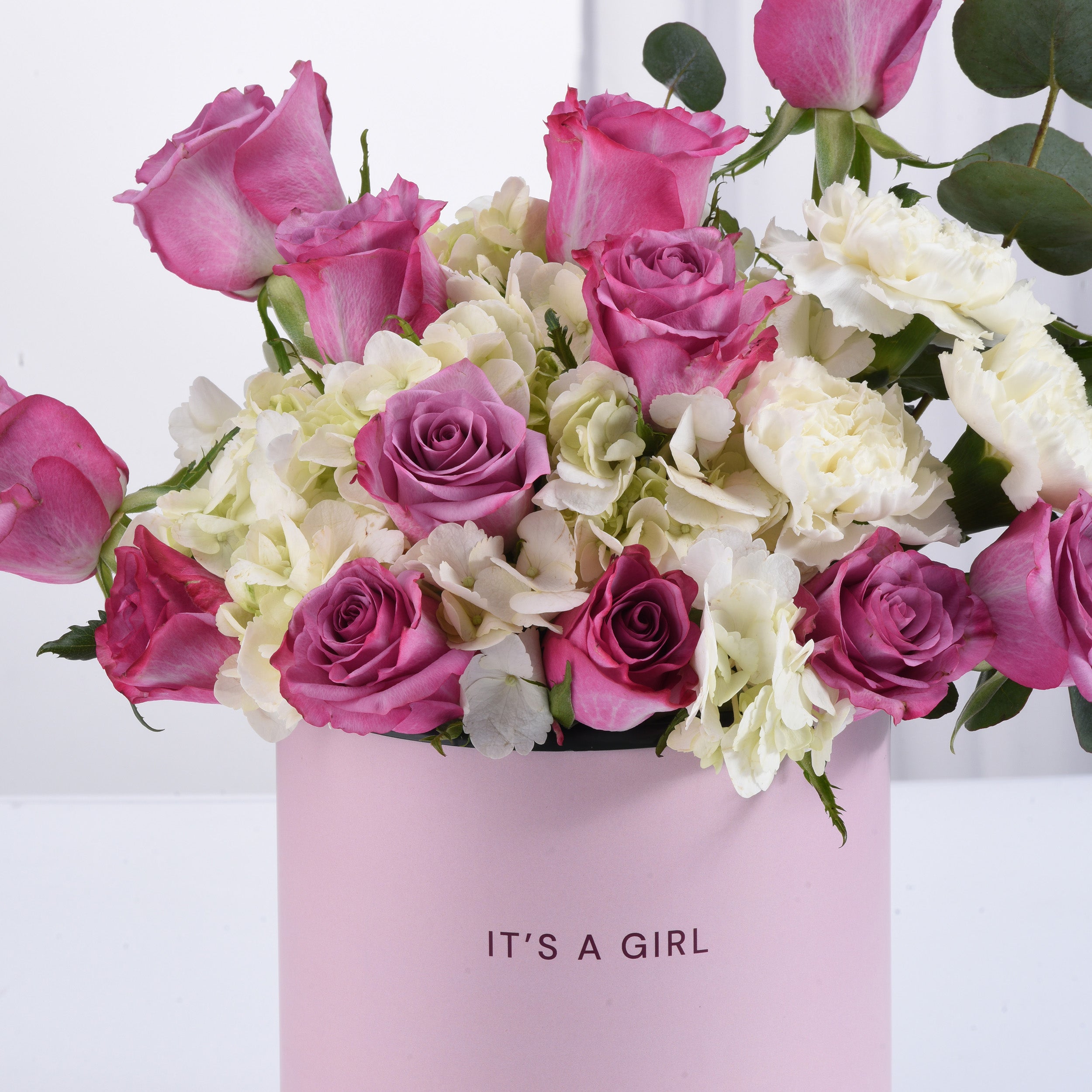 Pink and white roses, hydrangeas, and eucalyptus in a "It&