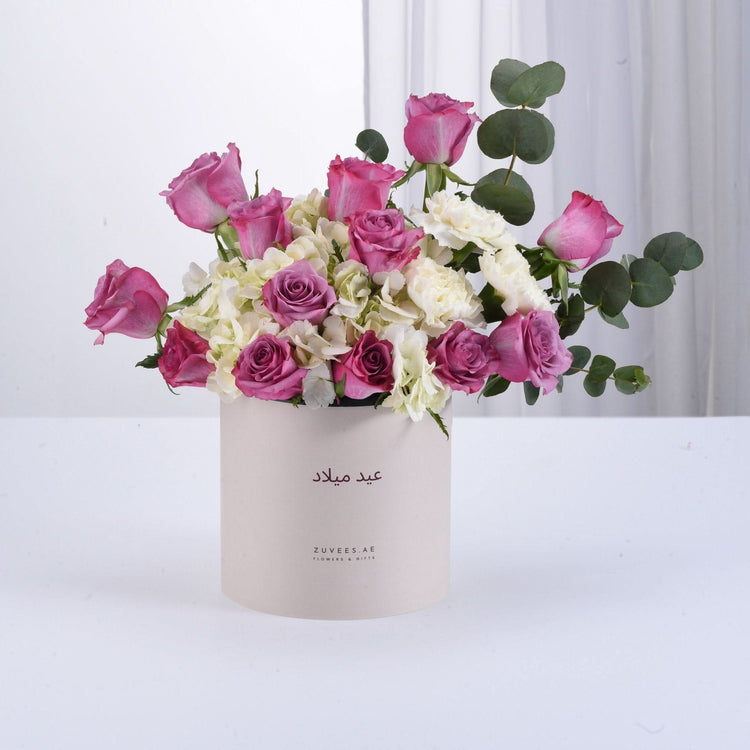 Pink roses, white hydrangeas, and eucalyptus in elegant beige box.