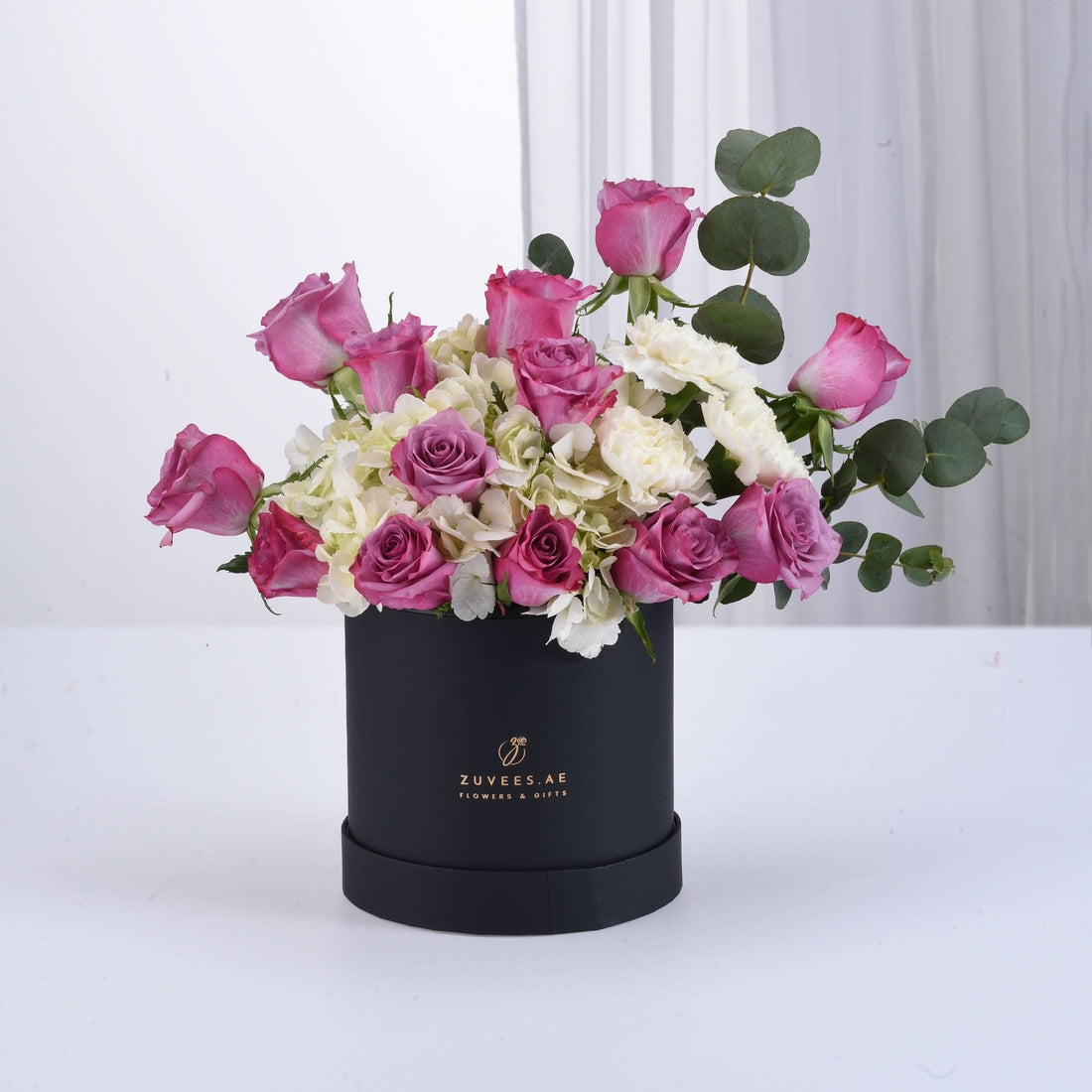 Elegant pink roses and white hydrangeas in matte black gift box.