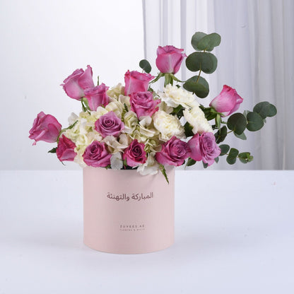 Pink roses and white hydrangeas in blush box with Arabic greeting.