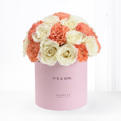 Soft pink box holds creamy roses and coral carnations, celebrating "It&
