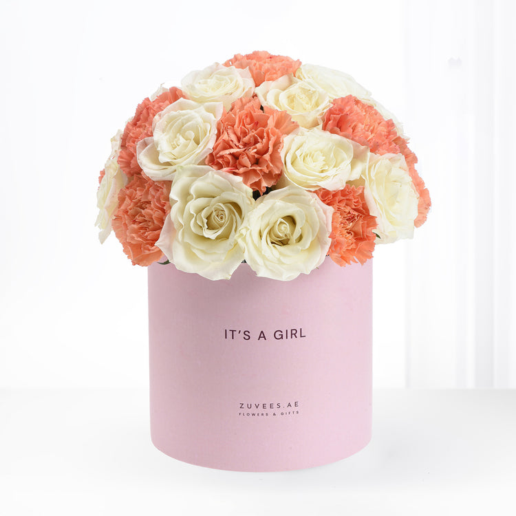 Soft pink box holds creamy roses and coral carnations, celebrating "It&