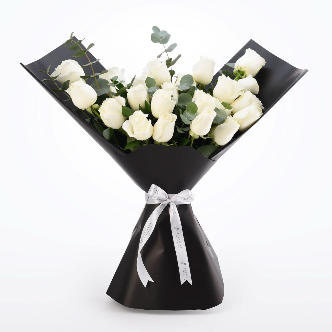 Elegant white rose bouquet wrapped in glossy black paper with silver ribbon.