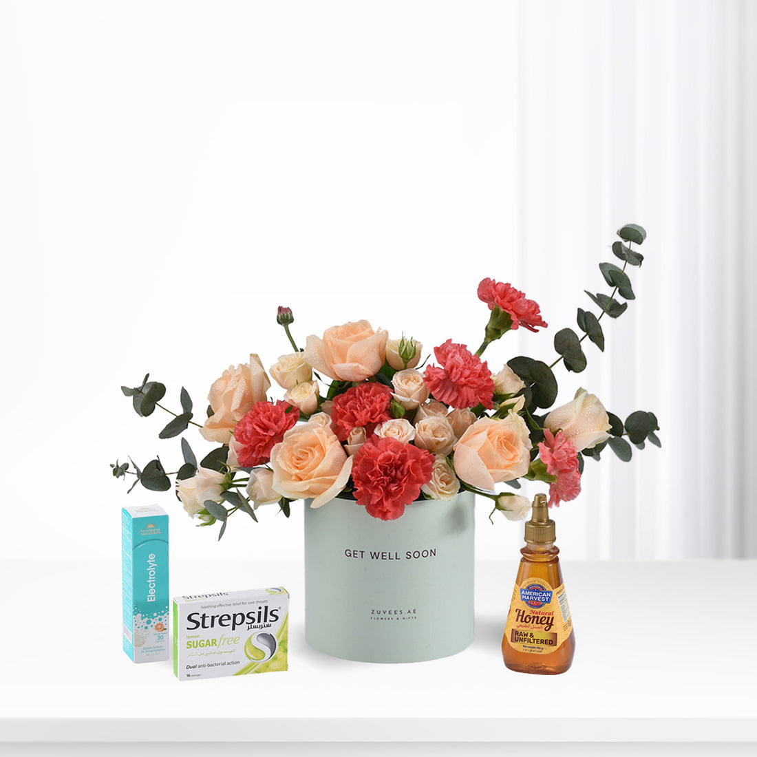 Pastel roses and carnations in mint vase with honey, throat lozenges, and electrolyte for recovery.