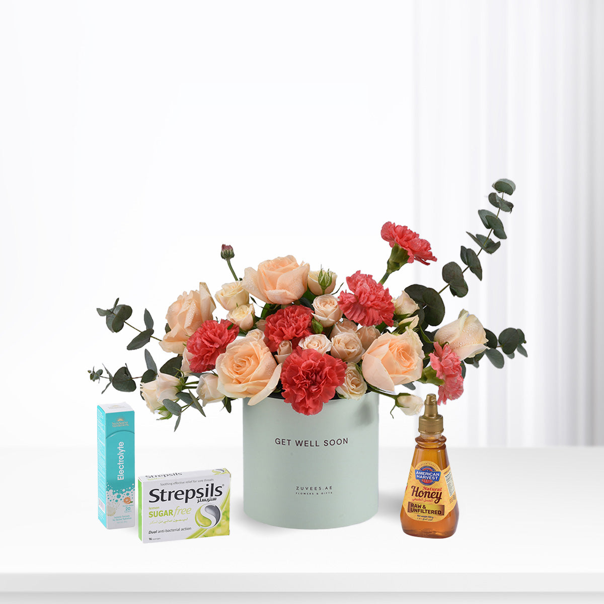 Pastel roses and carnations in mint vase with honey, throat lozenges, and electrolyte for recovery.