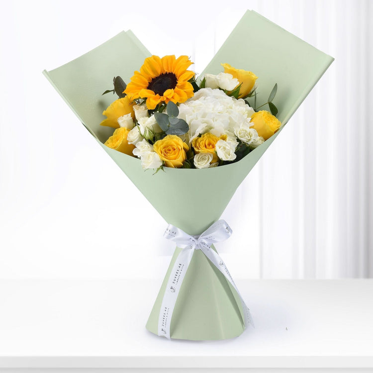 Sunflower, yellow and white roses bouquet in sage green wrap with white ribbon.