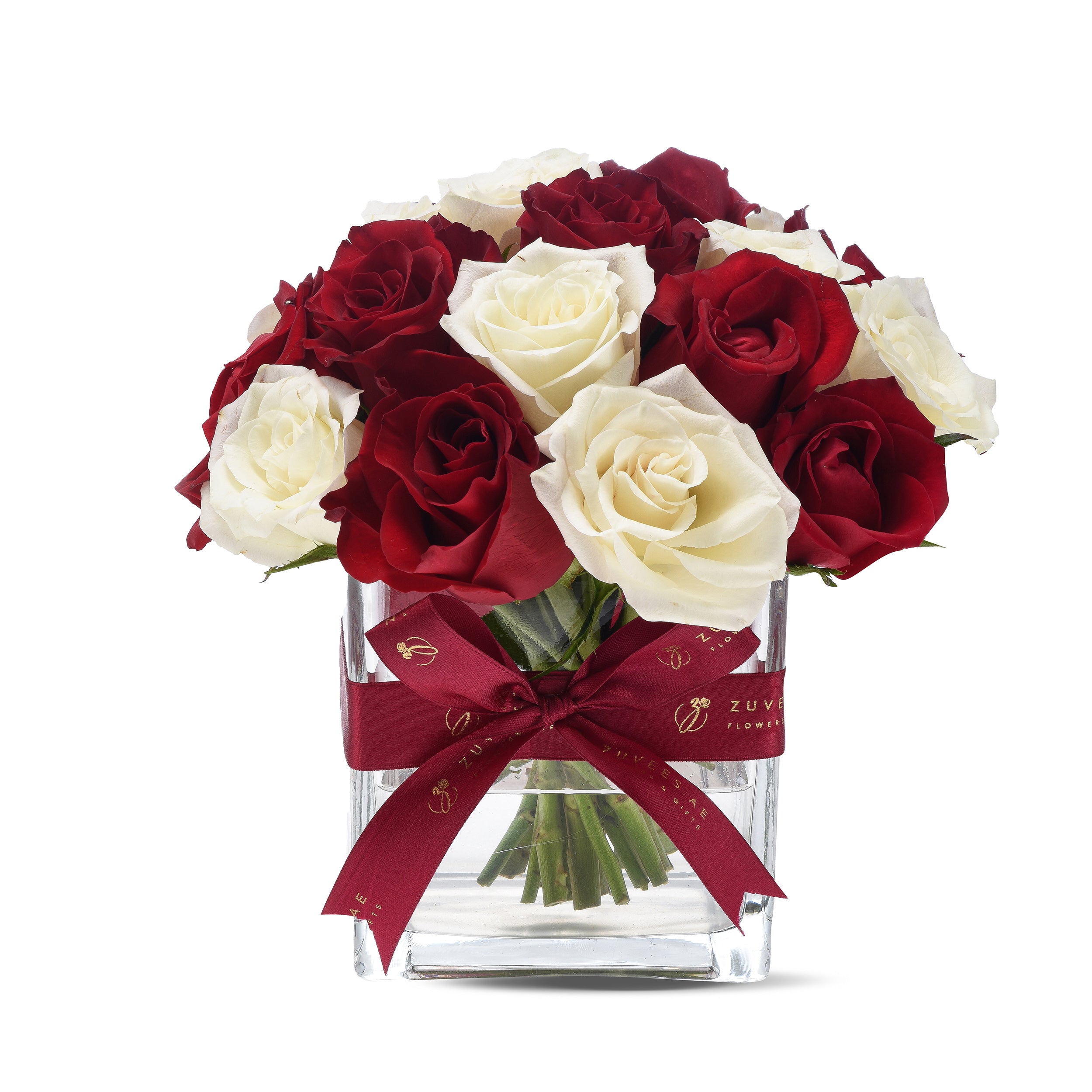 Elegant red and white roses in clear vase, adorned with burgundy ribbon.