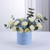 Light blue box holds white roses and hydrangeas, eucalyptus, celebrating “It’s a Boy.”
