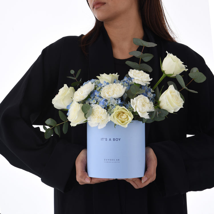 Light blue box holds white roses and hydrangeas, “It’s a Boy” gift.