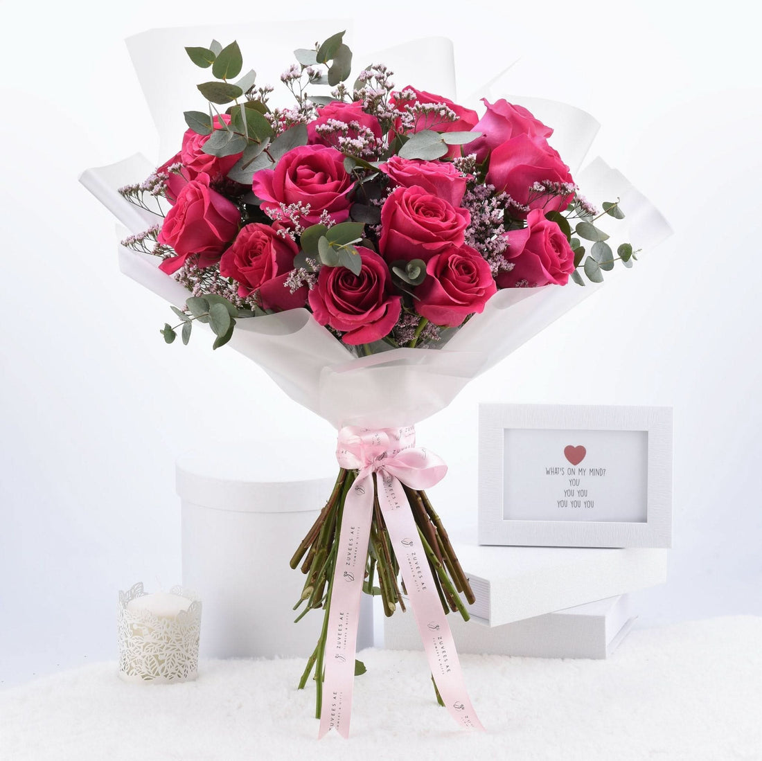 Vibrant pink roses, eucalyptus, and baby’s breath in crisp white wrap with pink ribbon.