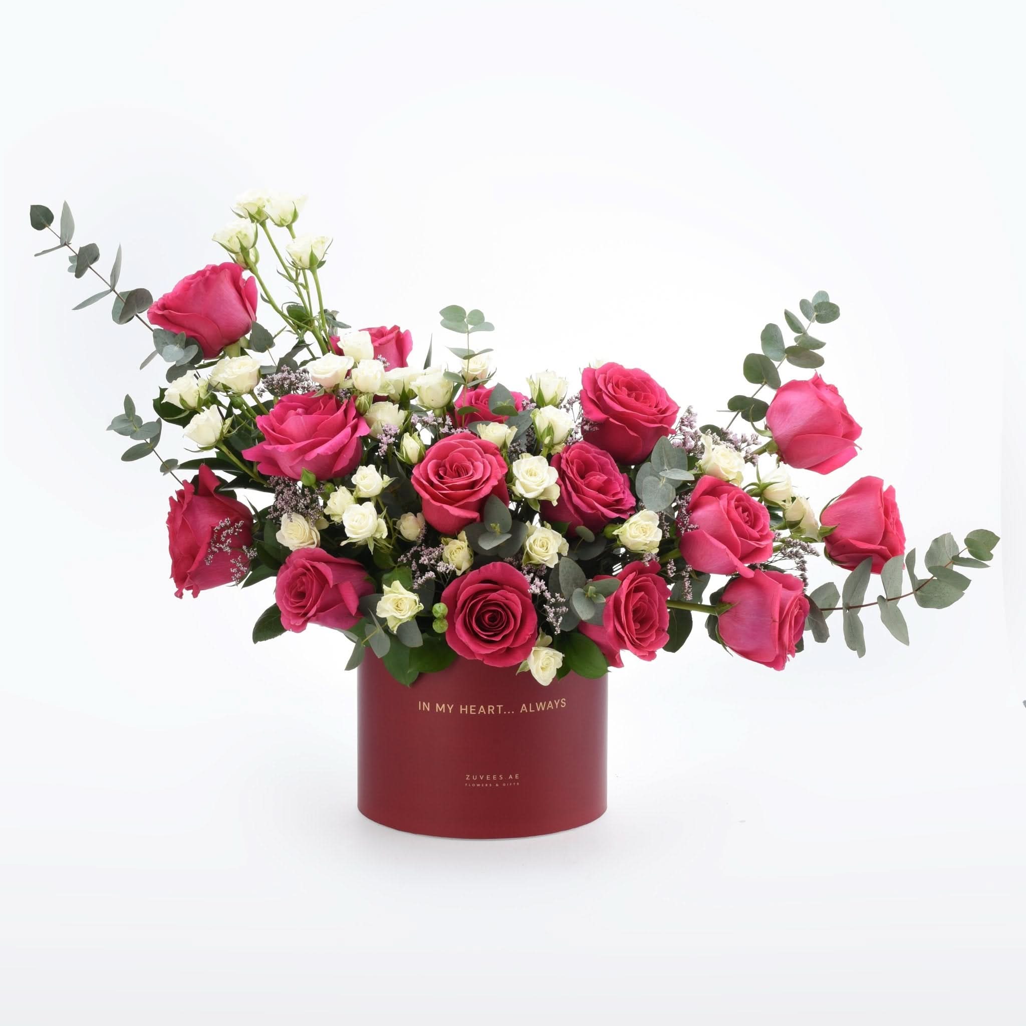 Vibrant pink and white roses in elegant red box with gold text.