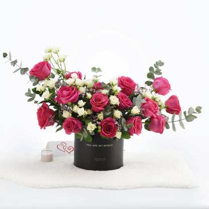 Vibrant pink and white roses in black box with "You Are My World" message.