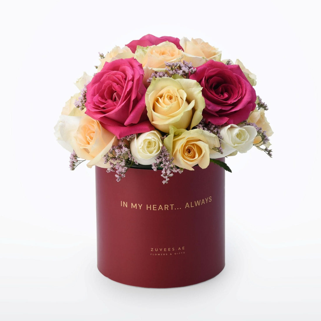 Vibrant pink, cream, and yellow roses in deep red box with gold "In My Heart... Always" inscription.