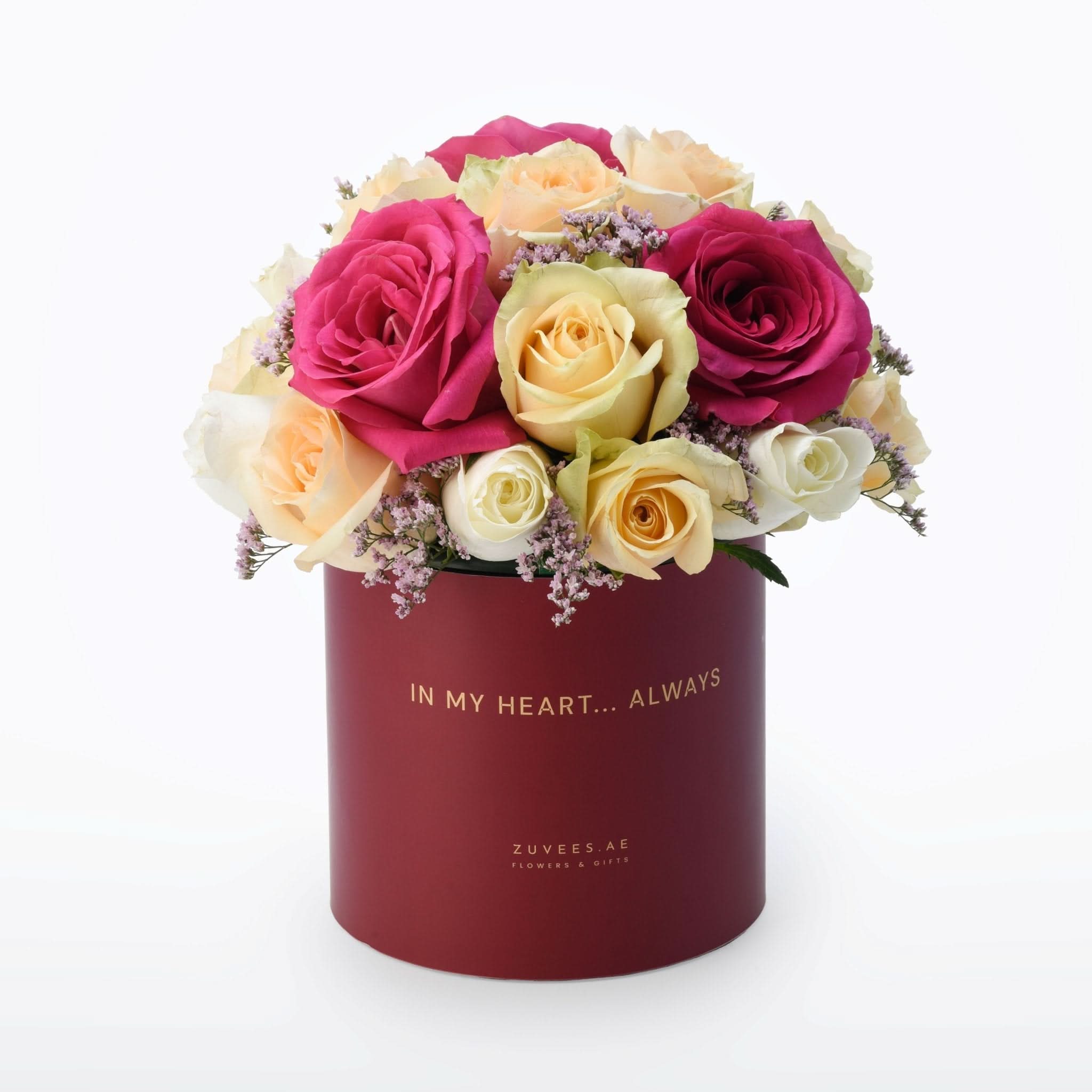 Vibrant pink, cream, and yellow roses in deep red box with gold "In My Heart... Always" inscription.