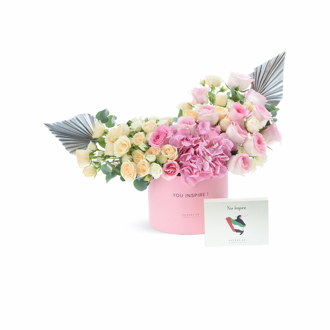 Pink box holds soft pink, cream roses and hydrangeas, accented with metallic silver wings.