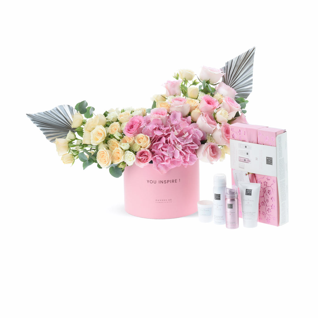 Pink floral arrangement with silver accents and matching skincare set.