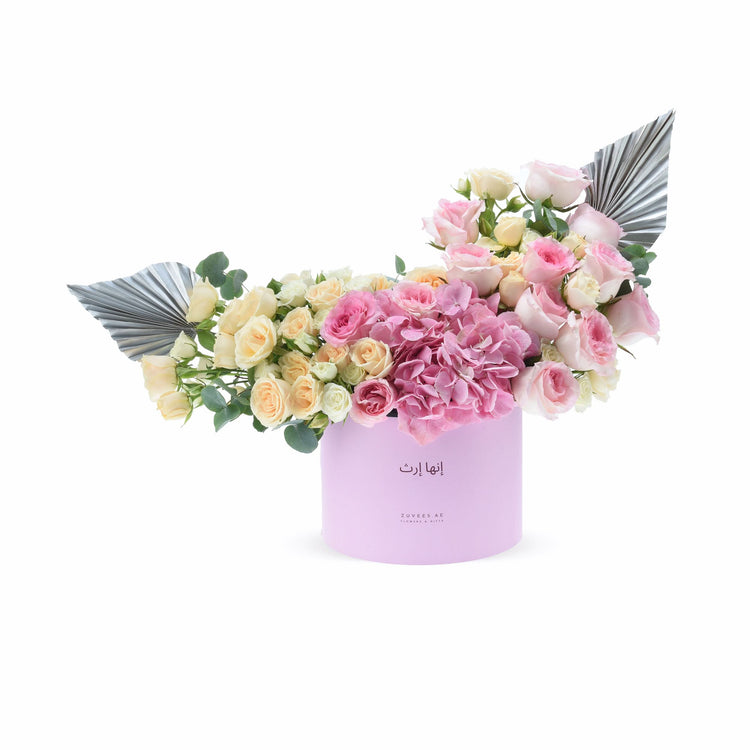Pink hydrangeas, blush roses, silver leaves in lavender box, elegant floral gift arrangement.