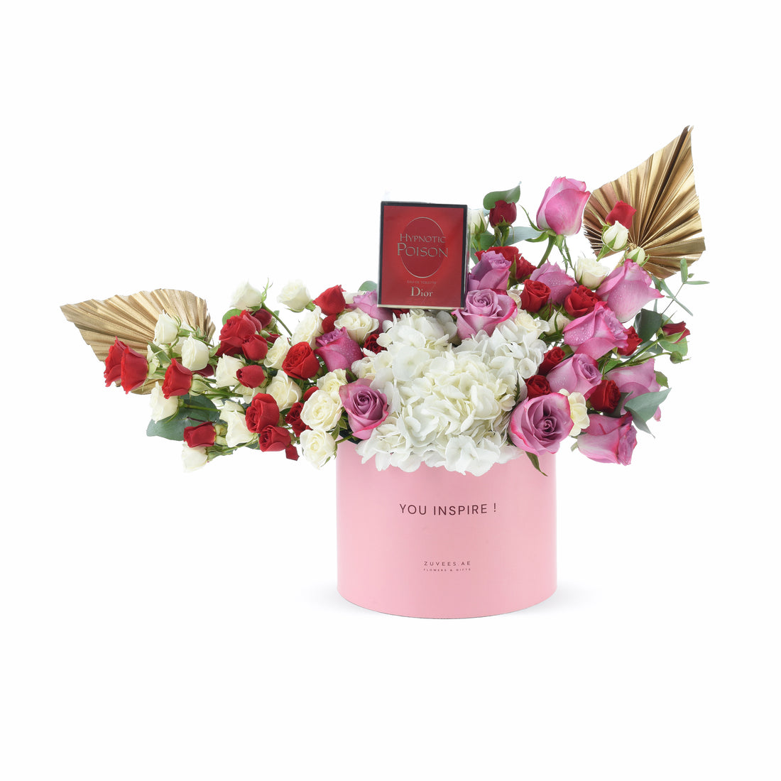 Pink cylinder holds red, white, and pink roses with hydrangeas, gold fans, and Dior perfume.