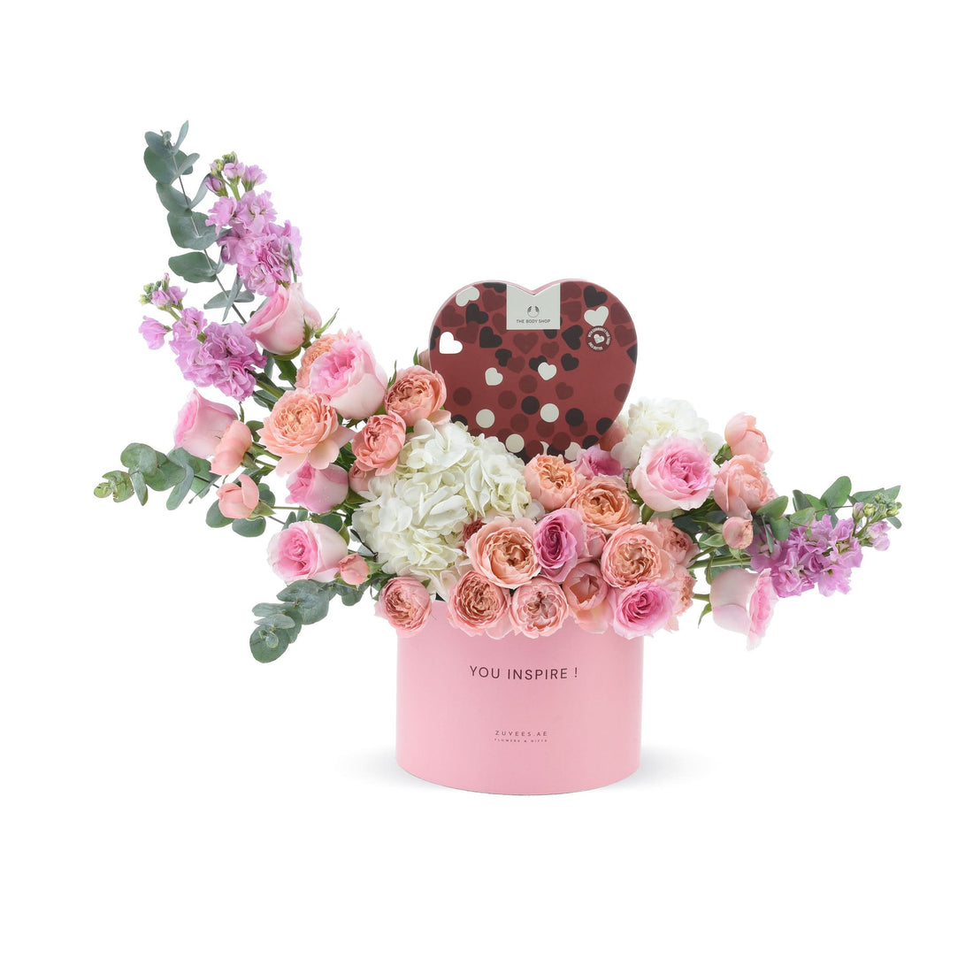 Pink floral arrangement in round box with heart-shaped gift, "YOU INSPIRE!" message.