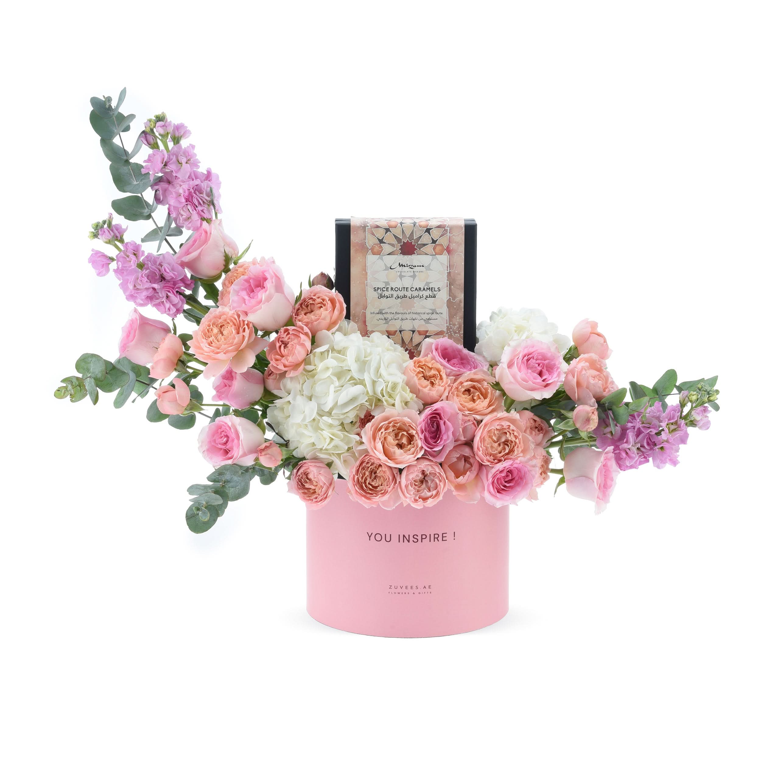Pink floral arrangement with roses, hydrangeas, eucalyptus, and spice caramel chocolates in a "YOU INSPIRE!" box.