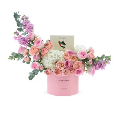 Soft pink roses, hydrangeas, and eucalyptus in a matching pink box with “You Inspire” card.