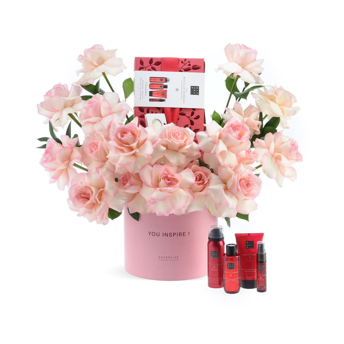 Pink roses in branded cylinder, surrounded by Rituals skincare set.