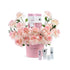 Soft pink roses bloom around a branded pink vase and luxury skincare set.