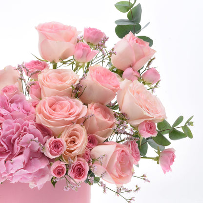 Soft pink roses, hydrangeas, and eucalyptus in elegant arrangement.