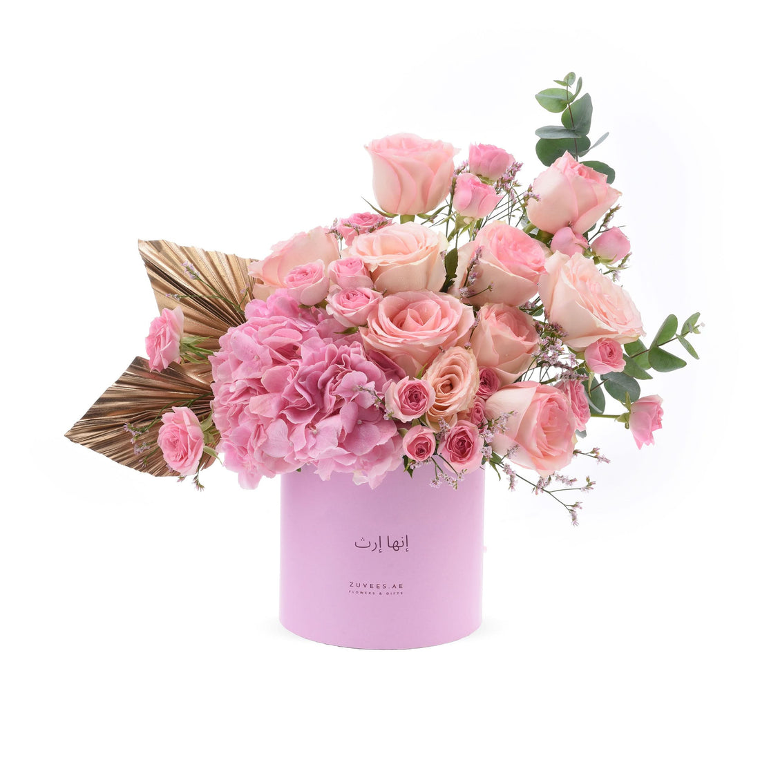 Soft pink roses and hydrangeas in lavender cylinder with gold leaf accent.