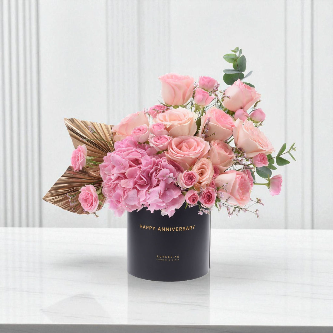 Elegant pink roses and hydrangeas in black "Happy Anniversary" vase with gold leaf accent.