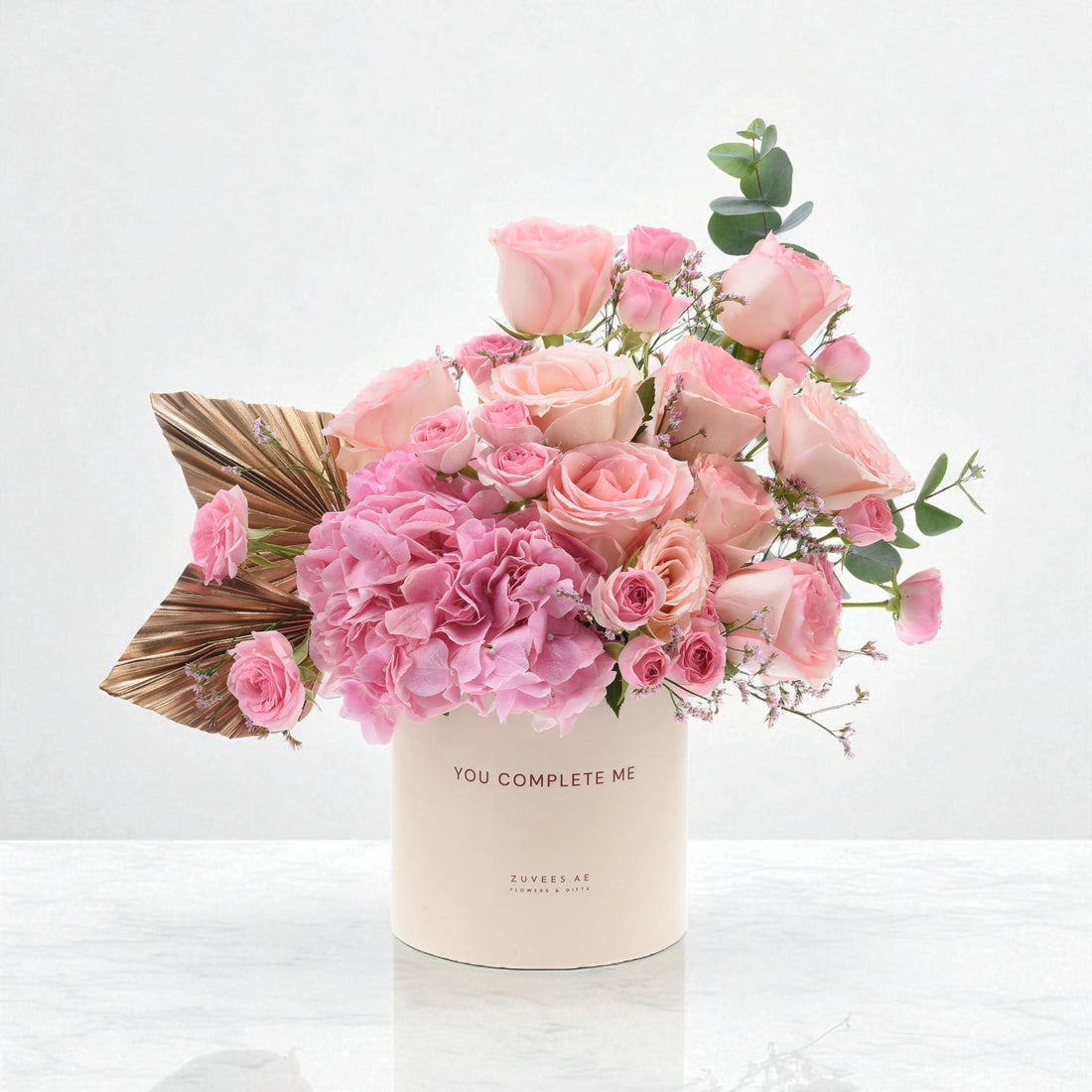 Pink roses and hydrangeas in cream box with "You Complete Me" text.