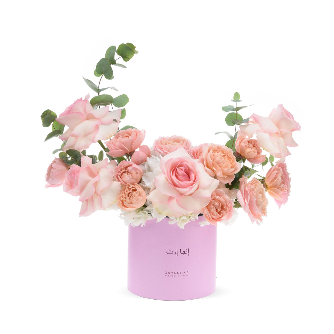 Soft pink roses and eucalyptus in pastel pink cylinder vase.