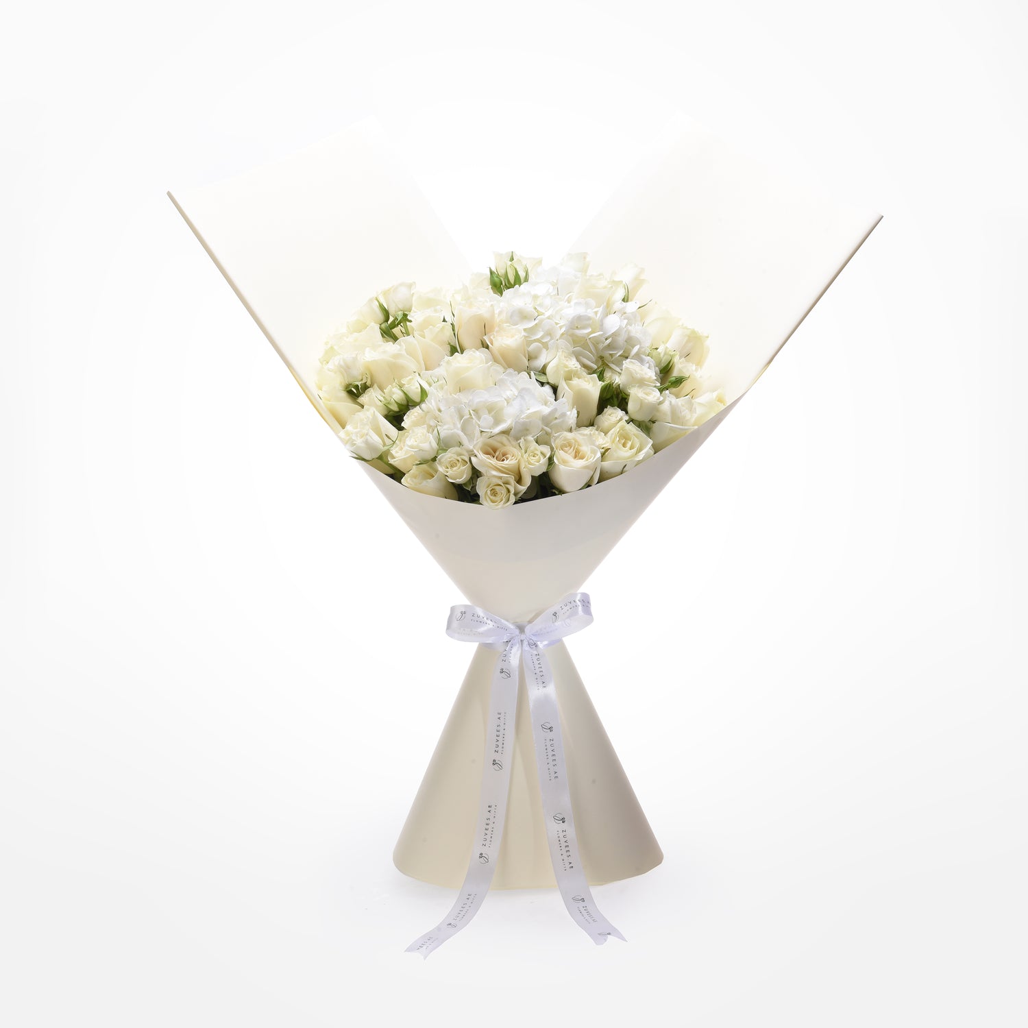 Elegant white rose bouquet with hydrangeas, wrapped in cream paper, tied with branded ribbon.