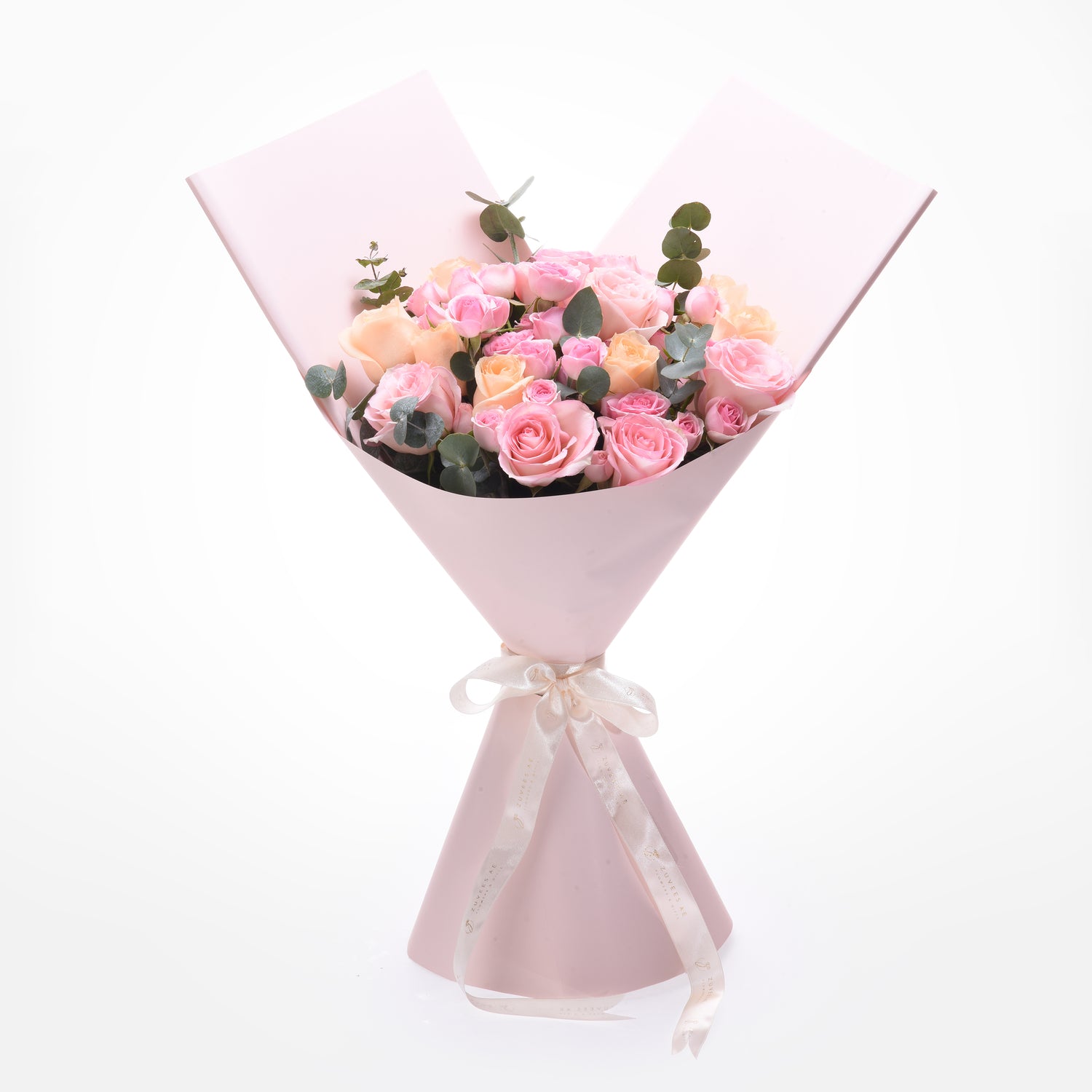 Soft pink roses and eucalyptus wrapped in matching paper with elegant cream ribbon.