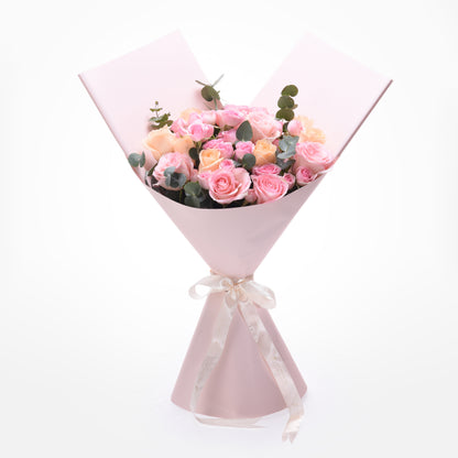 Soft pink roses and eucalyptus wrapped in matching paper with elegant cream ribbon.