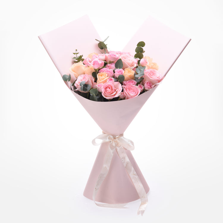 Soft pink roses and eucalyptus wrapped in matching paper with elegant cream ribbon.