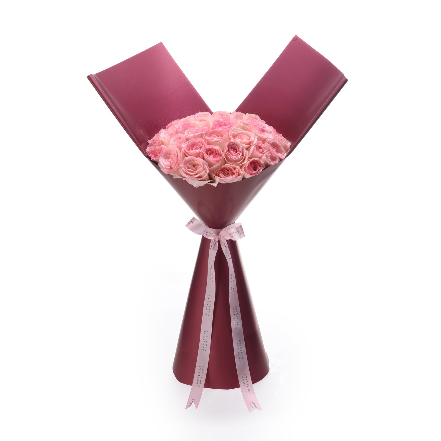 Soft pink roses in deep burgundy wrap, tied with branded ribbon.