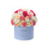 Pastel blue box overflowing with pink, peach, and white roses and carnations. "It&