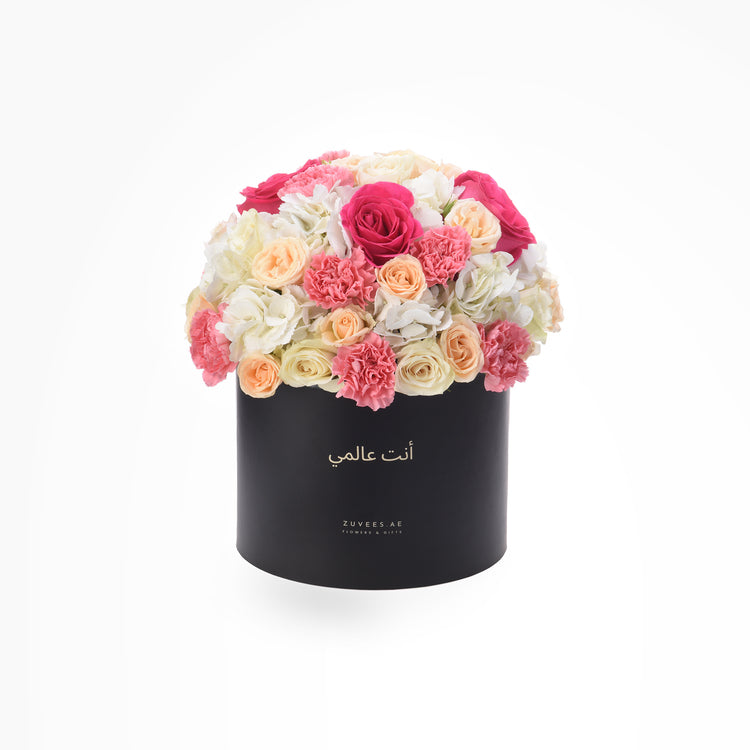 Elegant black box filled with vibrant pink, peach, and white roses and carnations.