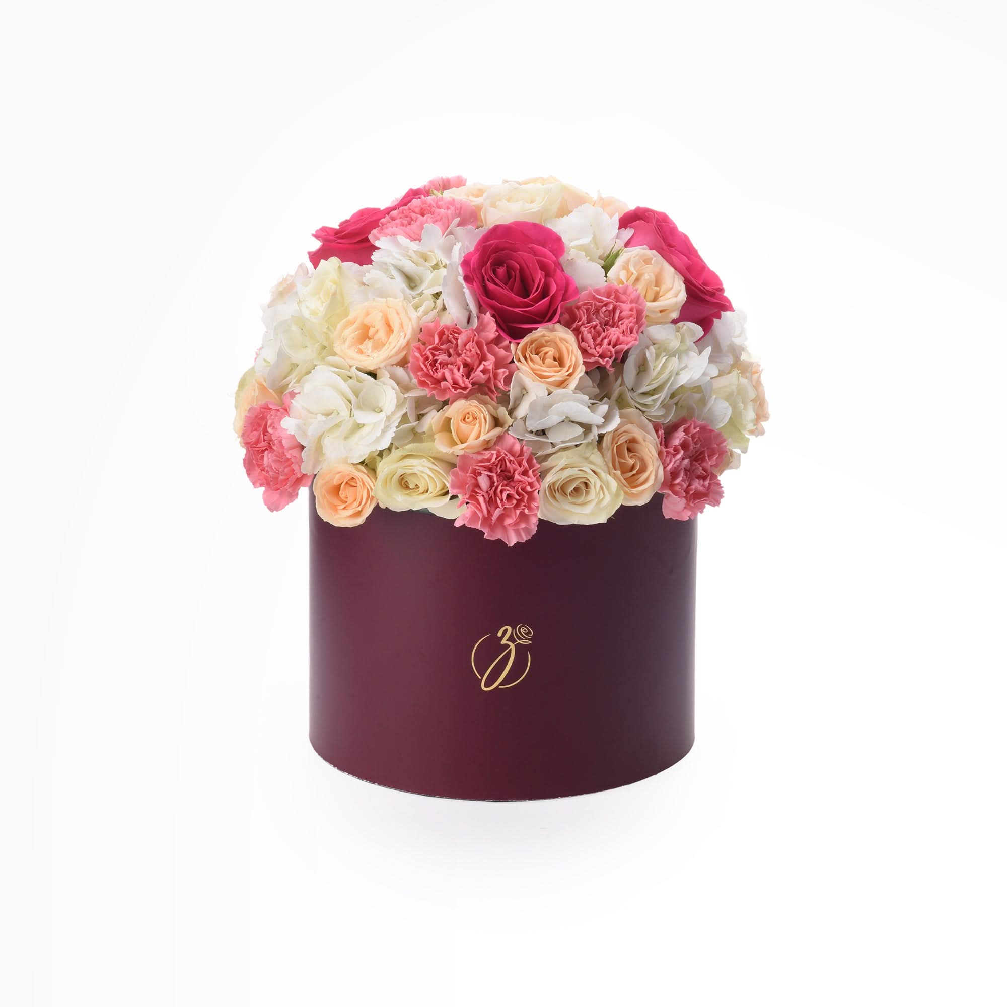 Vibrant pink, peach, and white roses &amp; carnations in elegant burgundy hat box with gold logo.