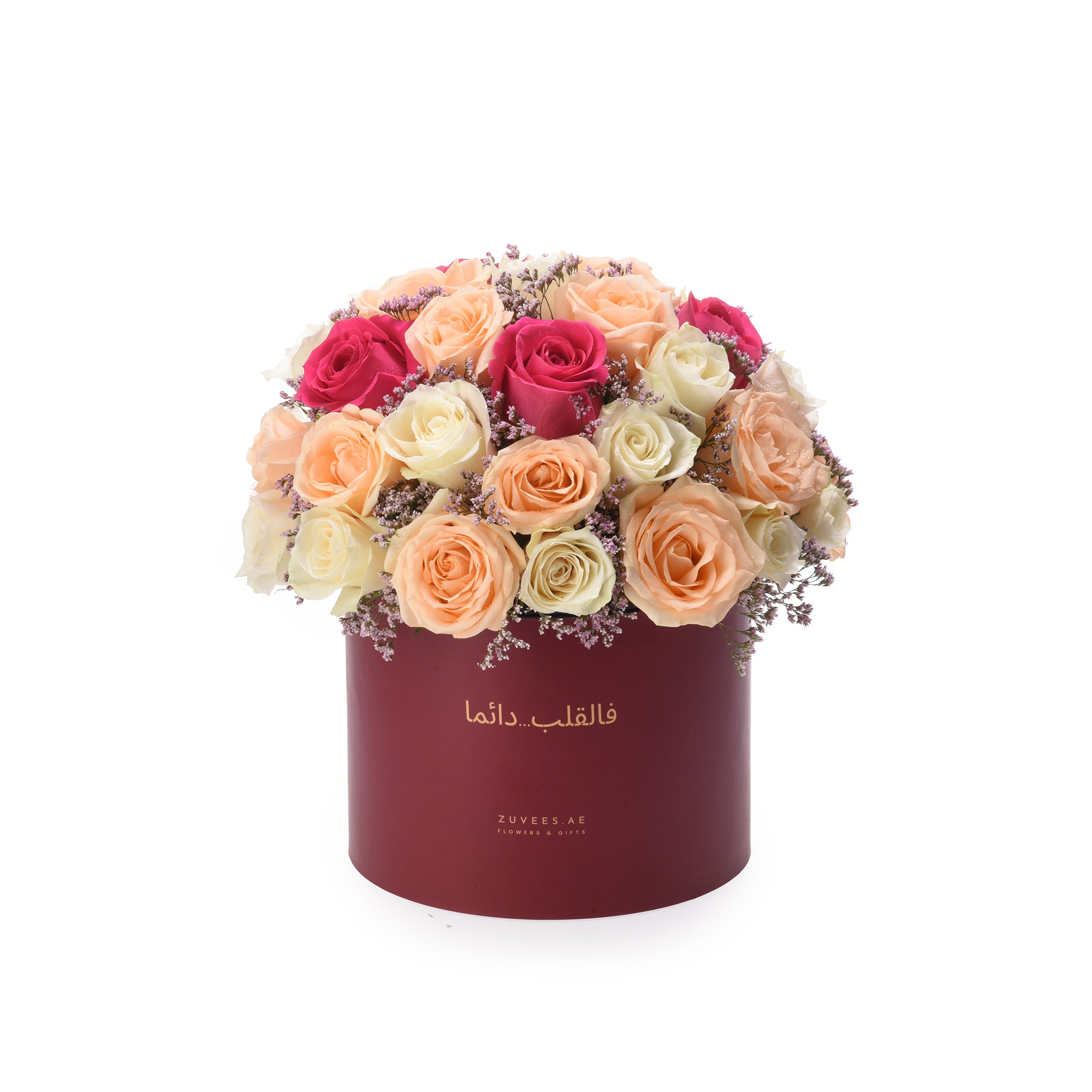 Vibrant multi-toned roses in burgundy box with Arabic script.