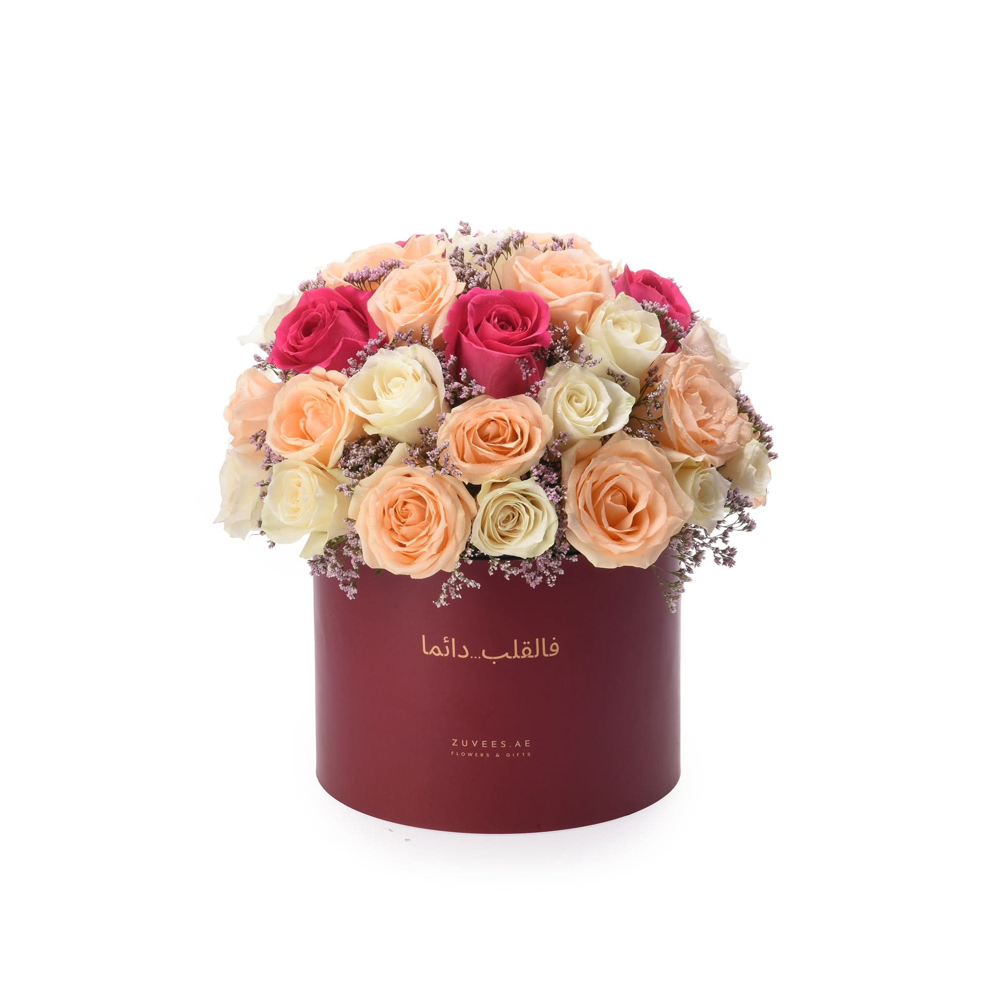 Vibrant multi-toned roses in burgundy box with Arabic text.