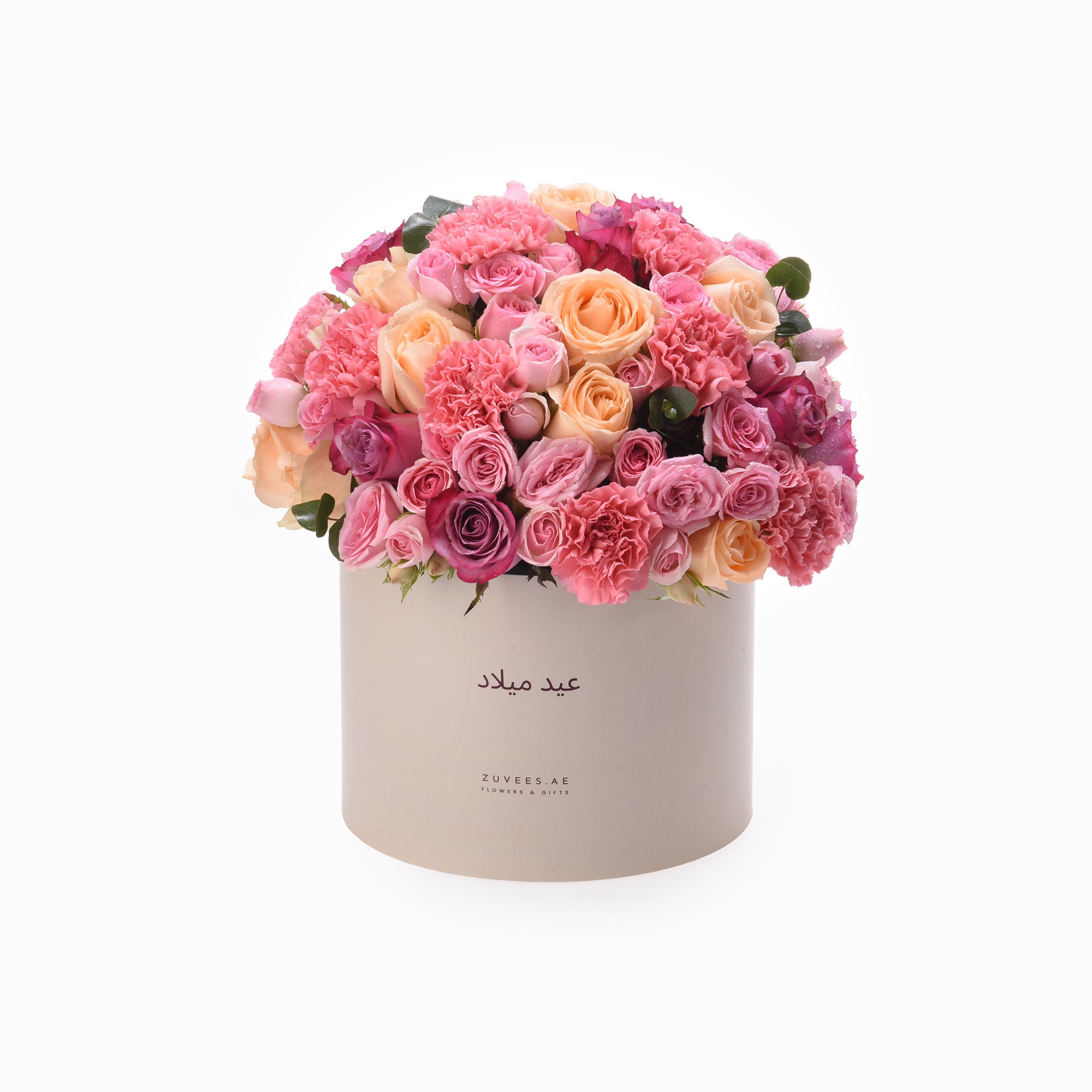 Pink and peach roses, carnations in cream box with Arabic script.