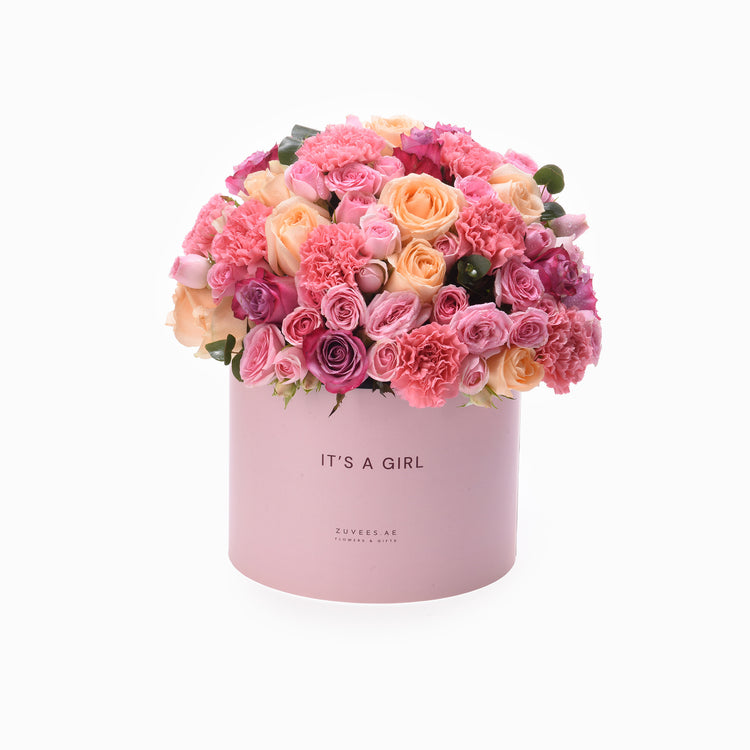 Pink box overflowing with vibrant roses and carnations, celebrating "It&