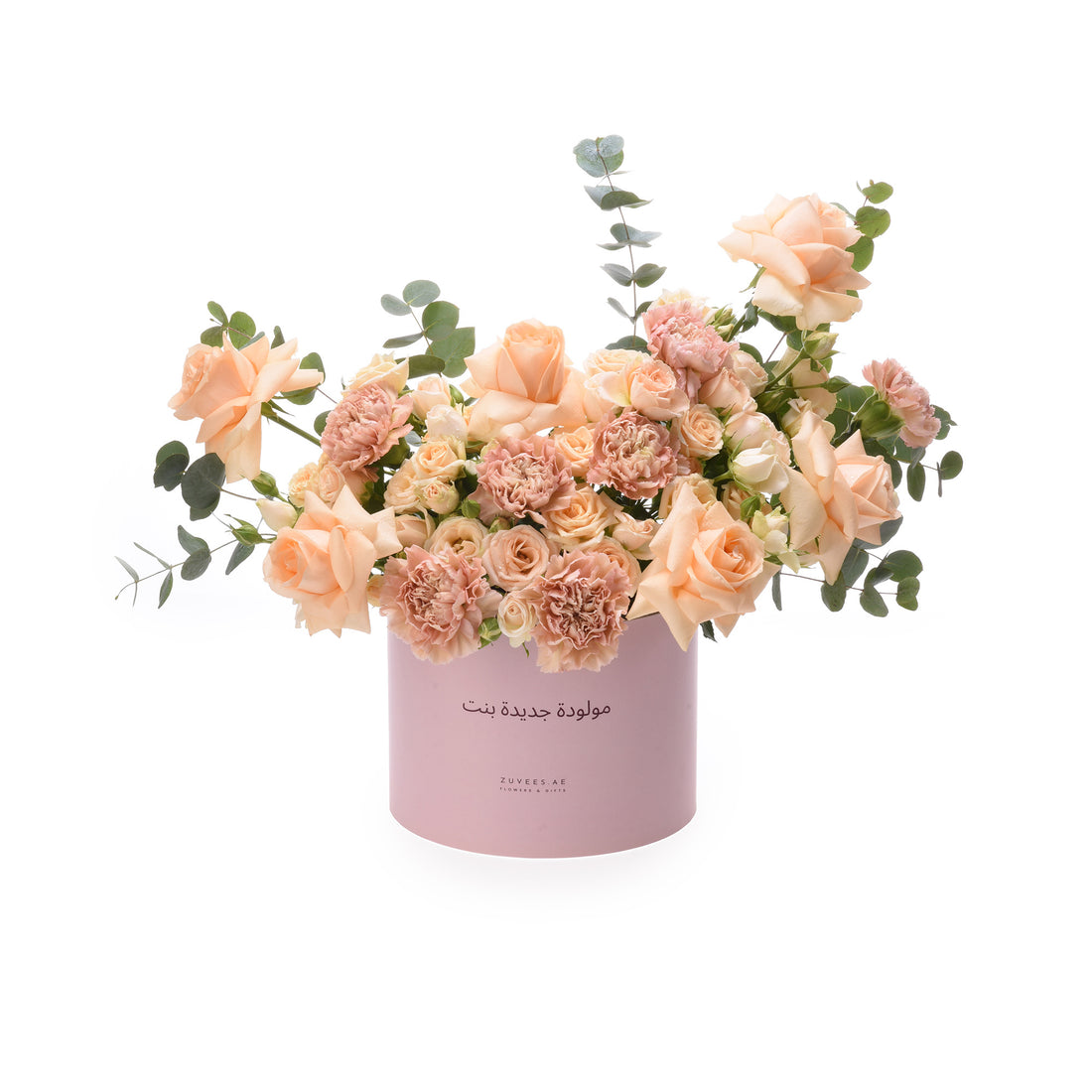 Soft peach roses and carnations in pastel pink box with Arabic text.