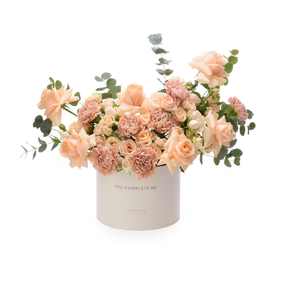 Soft peach roses and carnations in white box reading "You Complete Me".