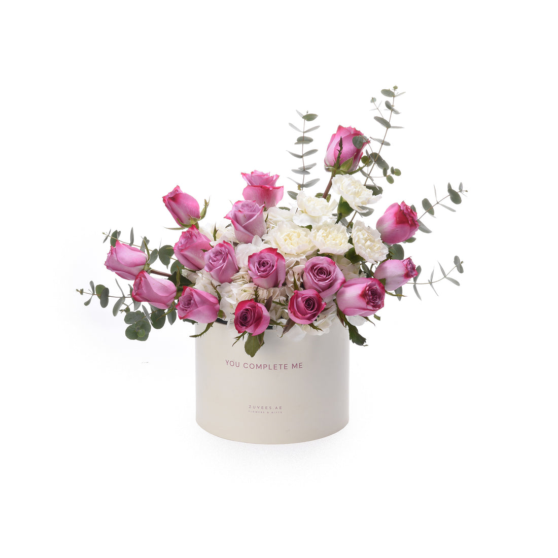 Pink roses and white blooms in a white box reading "You Complete Me".