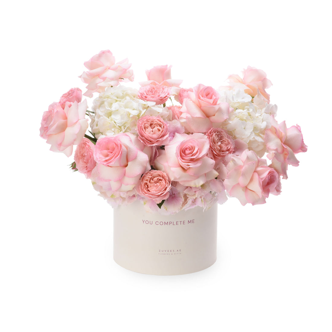 Soft pink roses and white hydrangeas in a cream box with "You Complete Me" text.