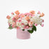 Soft pink and peach roses with white hydrangeas in a pastel pink box reading "IT&